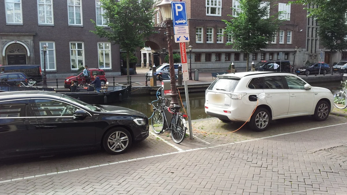 Twee plug-in hybrides laden aan een openbare laadpaal aan een Amsterdamse gracht