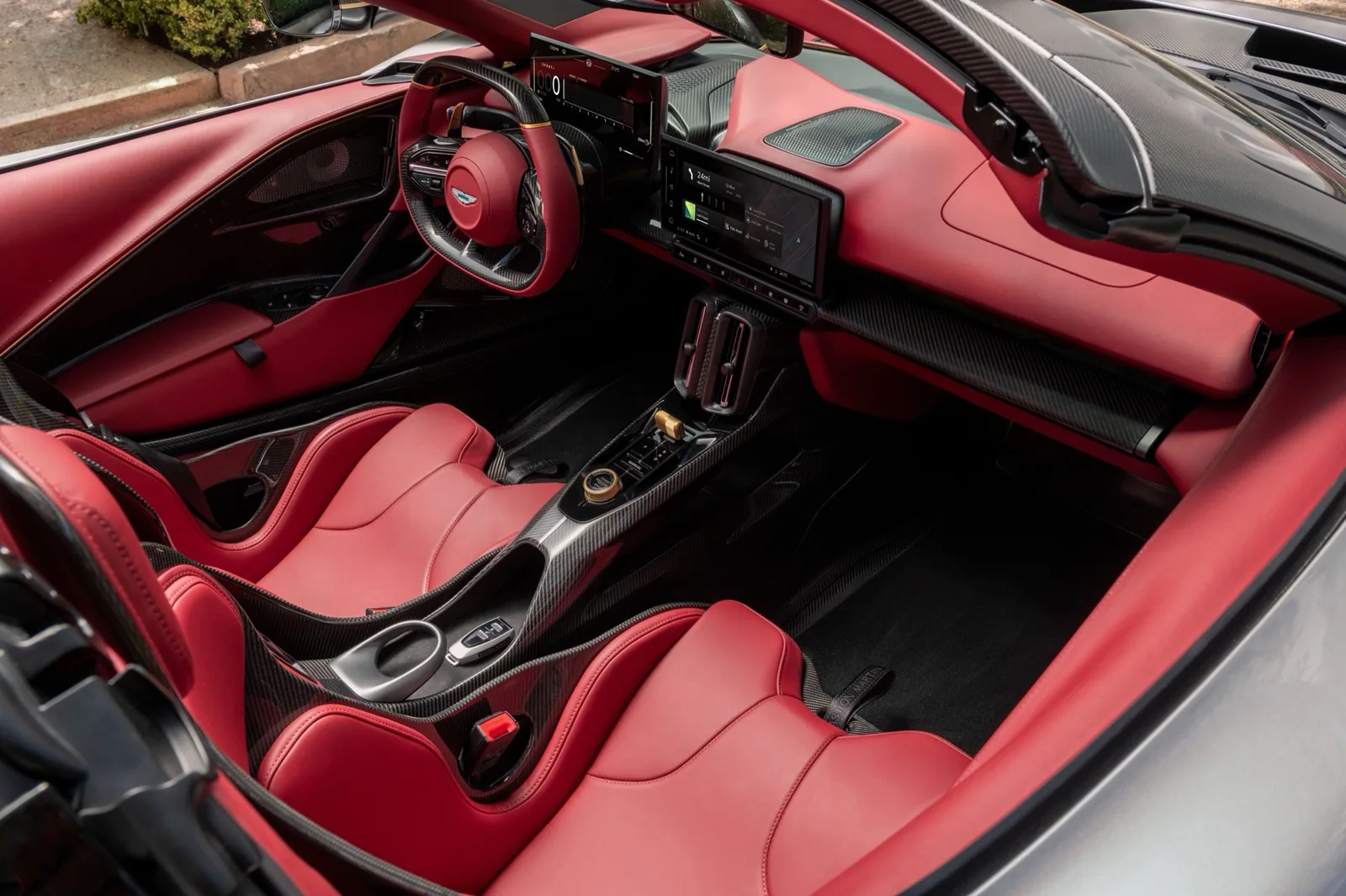 Interieur van de Aston Martin Valhalla Spider met rood leer, koolstofvezel en twee schermen
