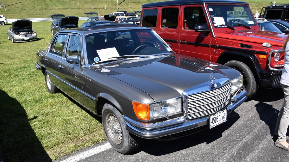 Grijze Mercedes-Benz 450 SEL 6.9 uit de W 116-reeks van schuin voren op een klassiekerevenement