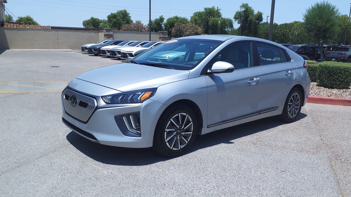 Zilvergrijze Hyundai Ioniq Electric van schuin voren op een parkeerplaats